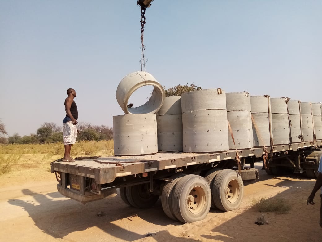 Anilhas de betão para os poços melhorados estão a ser descarregados nas comunidades de Naulila ao longo do rio