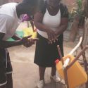 Demonstrating the correct way to wash hands to a family with a new tippy tap system