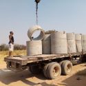 Concrete rings for the improved wells are being unloaded in Naulila communities along the river